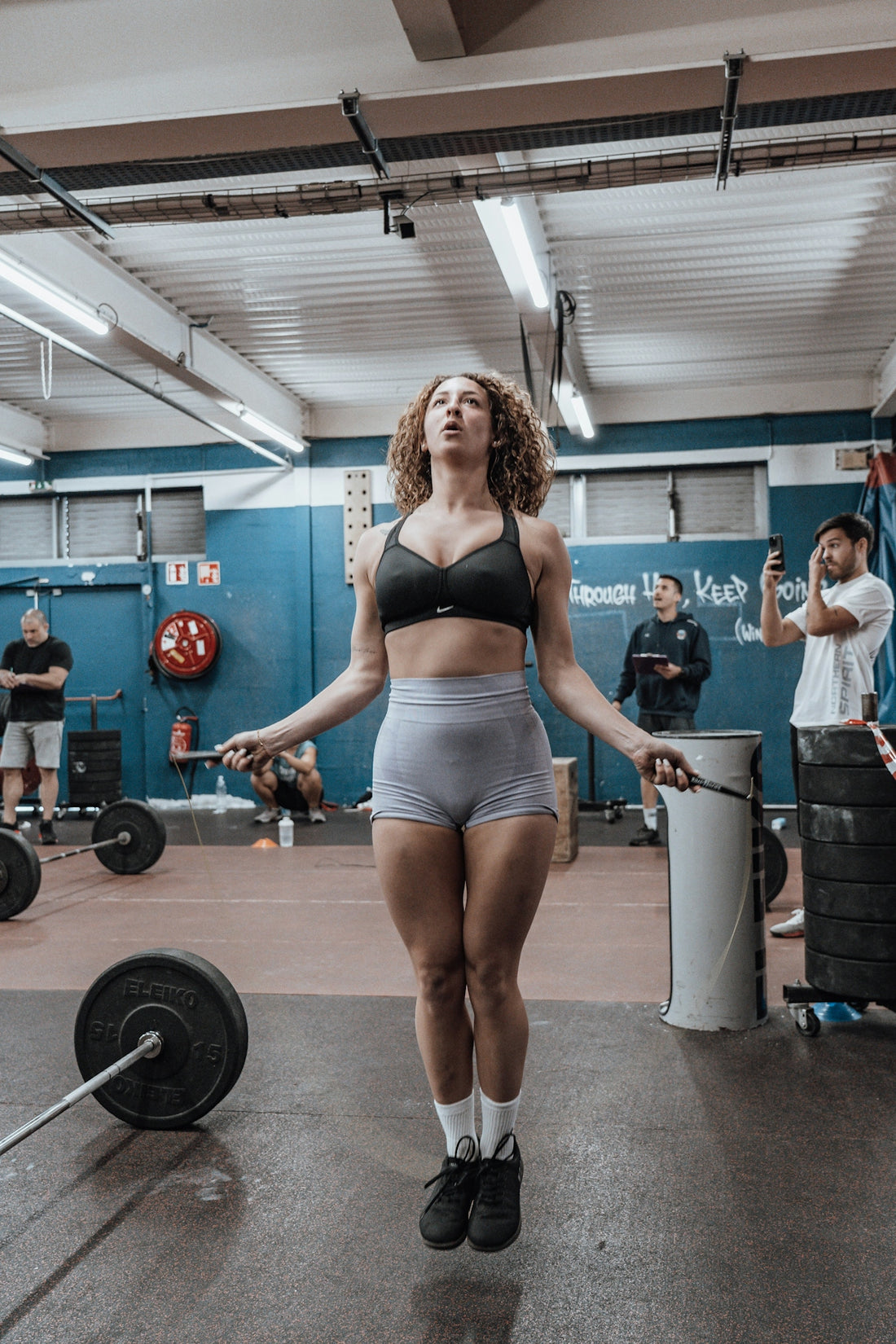 a woman in a gym with a barbell