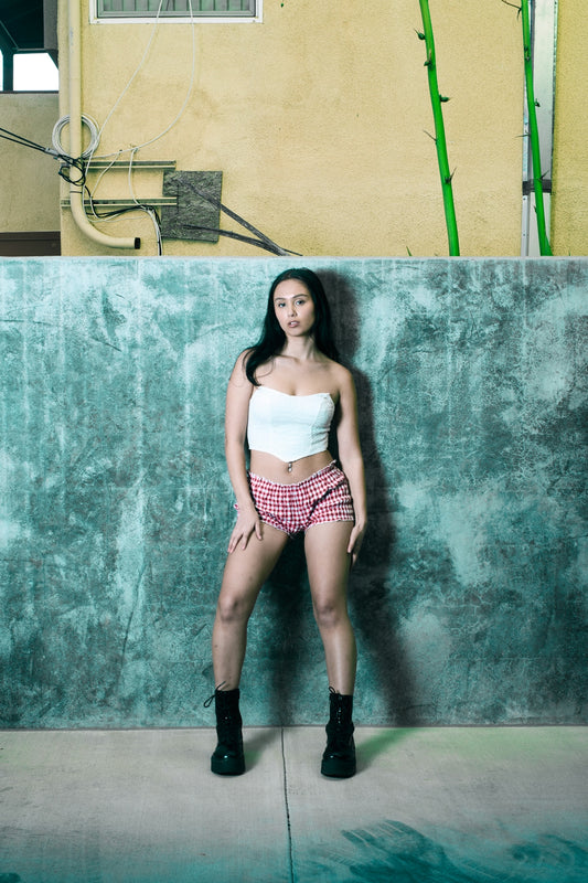 A woman poses confidently in a unique outfit.