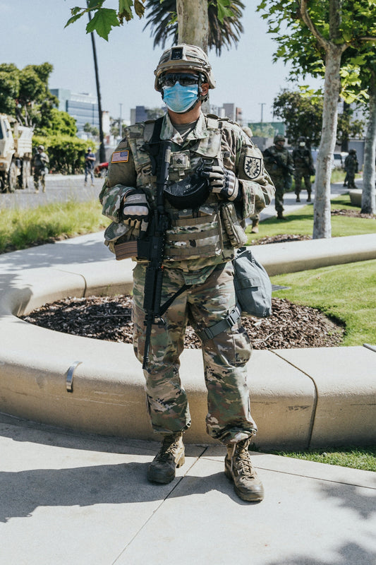 man in green and brown camouflage uniform holding brown rifle