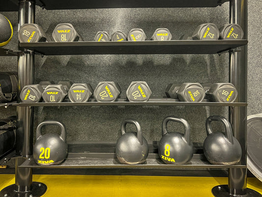 a rack of kettles and dumbbells in a gym