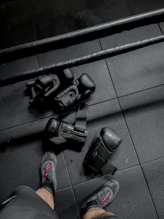 a person standing on a tiled floor next to a pair of black shoes