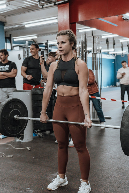 a woman holding a barbell in a gym