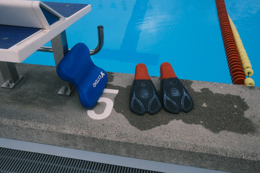 a pair of swimming shoes sitting next to a swimming pool