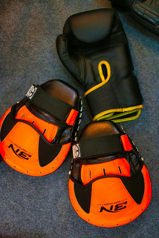 a pair of orange and black gloves and a pair of black and orange mitts