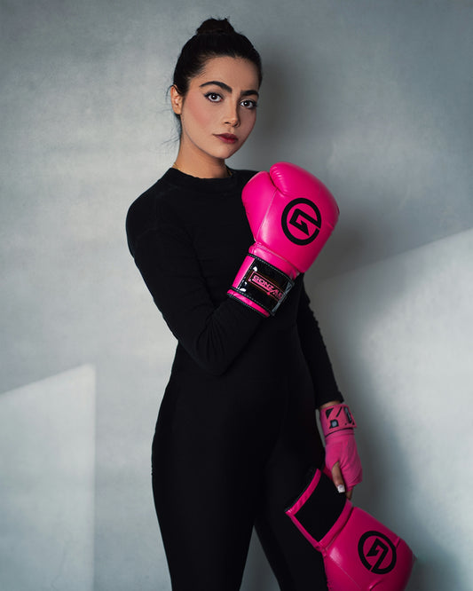 A woman wearing pink boxing gloves posing for a picture