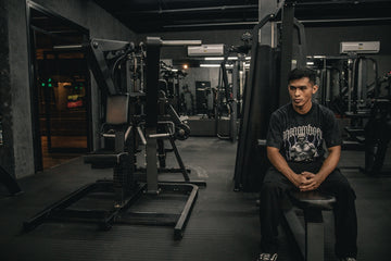 A man sitting on a bench in a gym