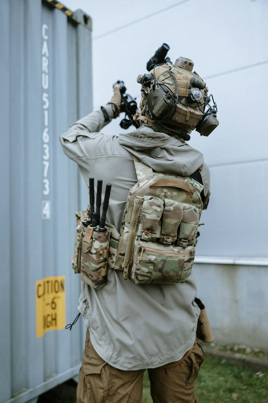 A man wearing a backpack and holding a rifle